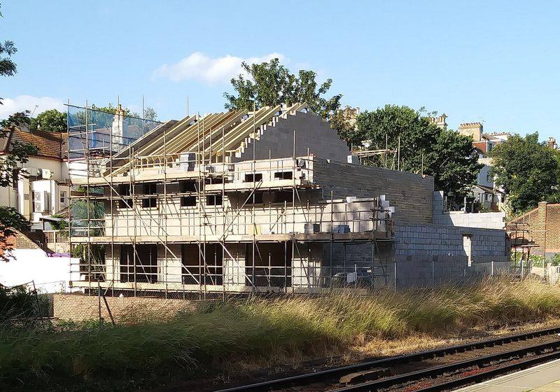 House under construction with roof framing and scaffolding