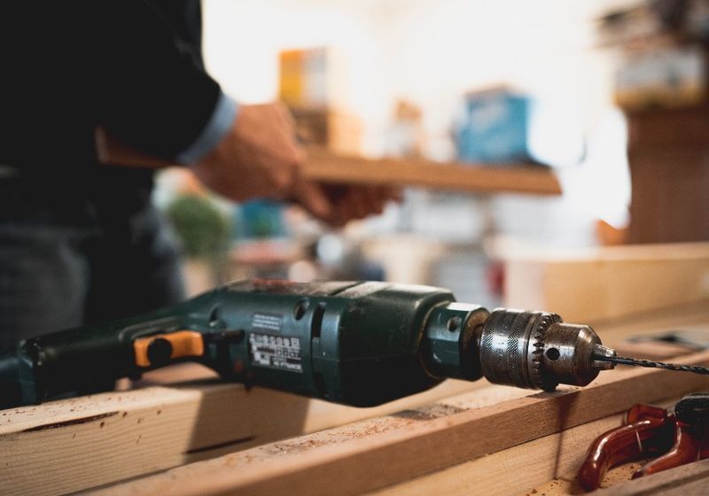 Carpenter drilling into a wood framing member
